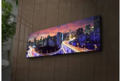 Lerretsbilde med LED-belysning 30x90 cm - Bysilhuett i skumringen med lysstråler fra veiene